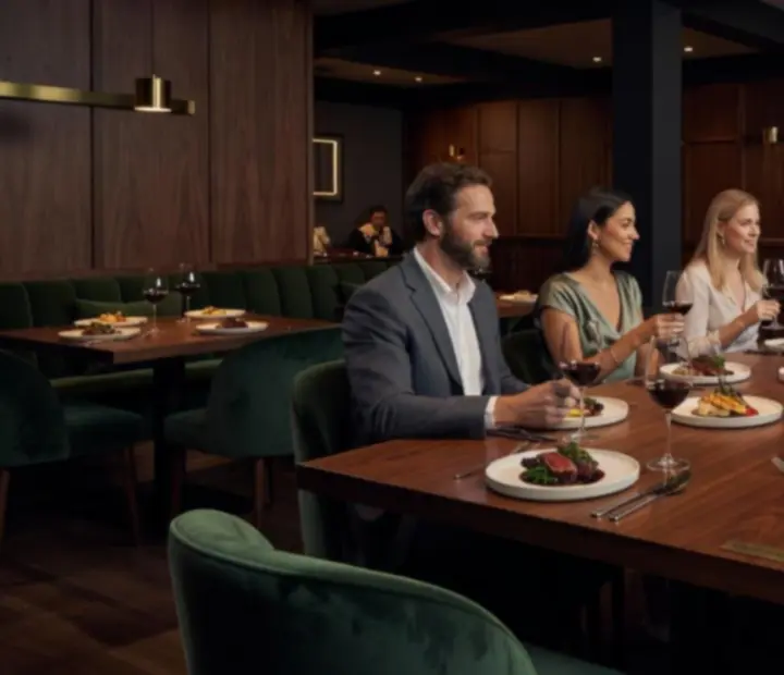 Cinematic evening view of a signature Australian fine dining table at TheKitchenTablle with plated dishes and candlelight.